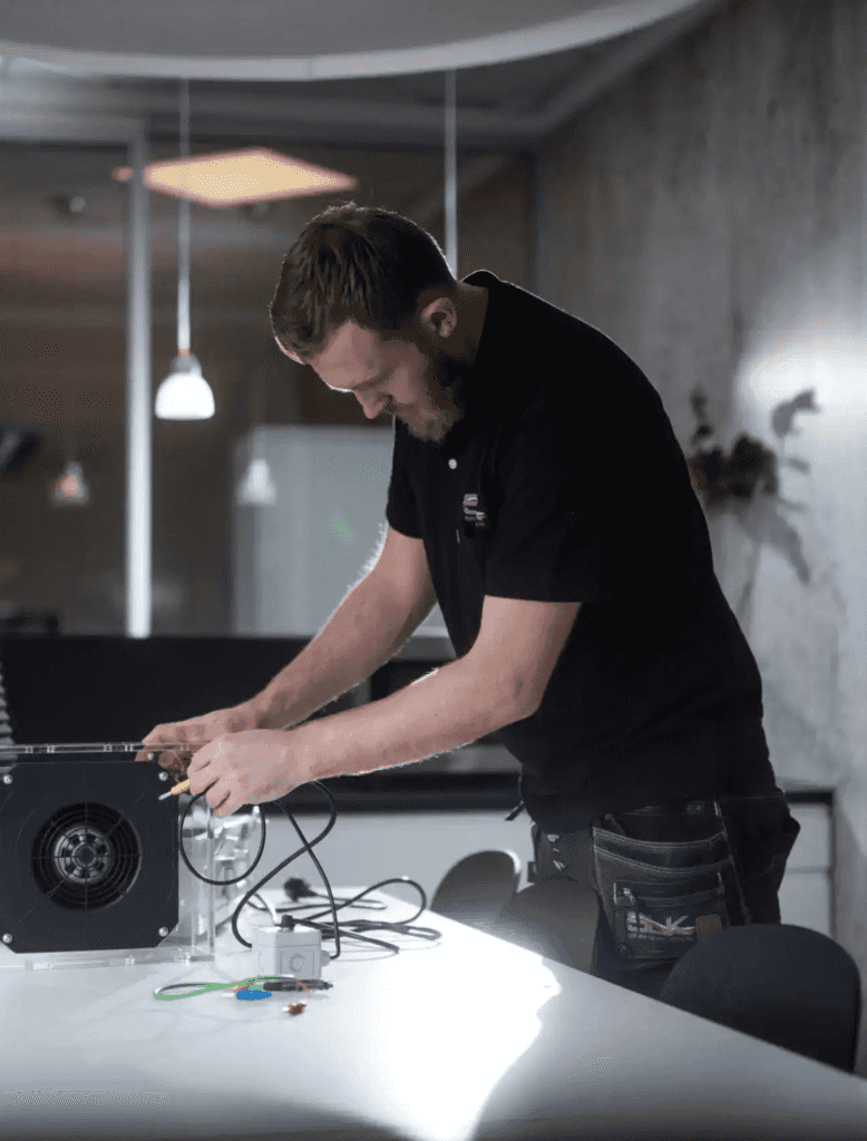 SLK - en mann i svart skjorte som jobber på en datamaskin